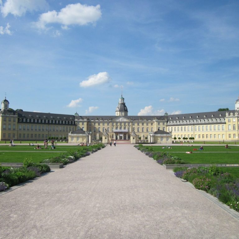 Schloss Karlsruhe mit Garten und blauem Himmel im Hintergrund.